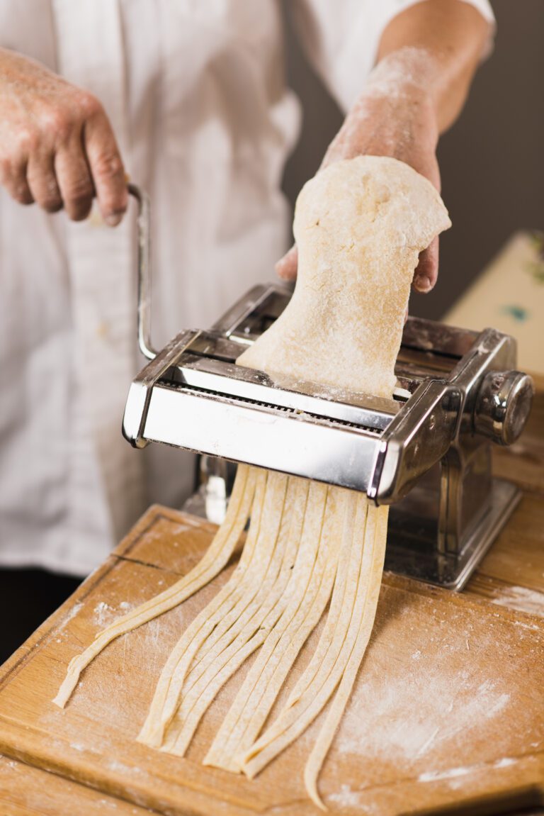 crop-person-cutting-dough-pasta